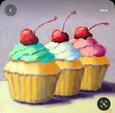 three cupcakes with colorful frosting and cherries on top are sitting in front of a purple background