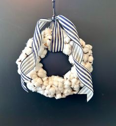 a wreath made out of cotton is hanging on the wall