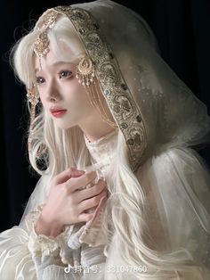 a woman dressed in white and wearing a veil with beads on it's head