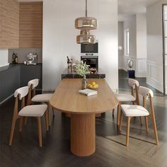 a dining room table with chairs and a vase on top of it in front of an oven