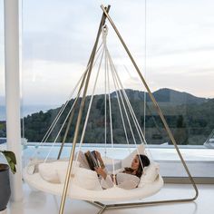 a woman laying in a white swing chair