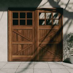 a wooden garage door sitting next to a potted plant