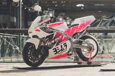 a red and white motorcycle parked in front of a building