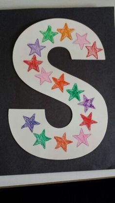 the letter s is made out of colored paper and has stars on it's side