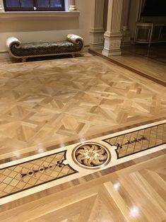 an empty room with wooden floors and ornate designs on the floor, in front of a window