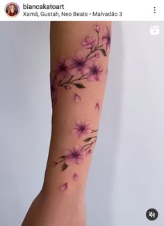 a woman's arm with pink flowers on it