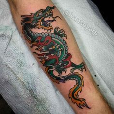 a man's arm with a dragon tattoo on the left side of his arm