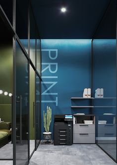 an office with blue walls and glass partitions to let light into the room,