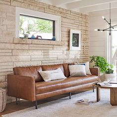 a living room with a couch, table and window in it's center area