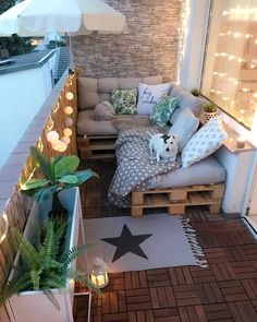 a small balcony with lights and pillows on it