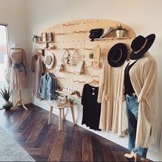 a room filled with hats and clothing on display next to a wall mounted coat rack