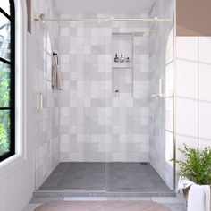 a walk in shower sitting under a window next to a rug on the side of a wall