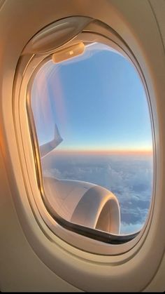 an airplane window looking out at the clouds