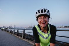 a woman wearing a bicycle helmet smiling for the camera