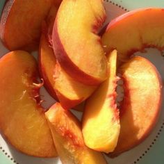 sliced peaches on a white plate sitting on a table