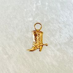 A highly detailed cowboy/cowgirl boot with a spur in 14-karat yellow gold.  A large ring at the top allows the charm to be dangled from an earring hoop, or suspended from a chain for a "charm necklace" or single pendant.  Message us if you need the jump ring for a pendant, hoops, or a chain. We have many options available. Also available is a sweet 14k cowboy hat as seen in the photos.  Here's the link:  https://vintageluxer.etsy.com/listing/1460963491   7/8 inch x 5/8 inch wide 14k Gold 1.8g Re Vintage Gold Jewelry For Rodeo, Western Style Gold Jewelry As Gift, Western Style Engraved Gold Jewelry, Engraved Gold Western Jewelry, Western Gold Engraved Jewelry, Boot Charm, Earring Hoop, Cowgirl Boot, Cowboy Cowgirl