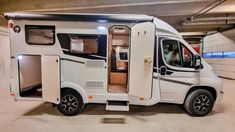 an rv parked in a garage with its doors open and the interior door ajar