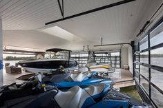 several jet skis lined up in a boathouse on the water's edge