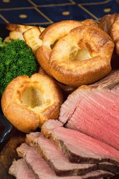 corned beef, broccoli and bread rolls on a plate with dipping sauce