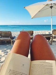 a person is reading a book on the beach