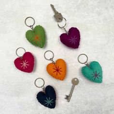 six heart shaped keychains with different colors and designs are shown on a white surface