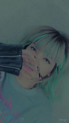 a woman with green hair and piercings on her face is posing for the camera