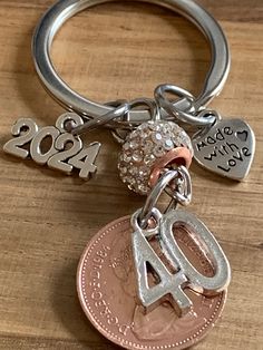 a penny keychain with the number twenty four on it and two charms attached to it