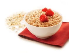 oatmeal with raspberries in a bowl on a red napkin next to it