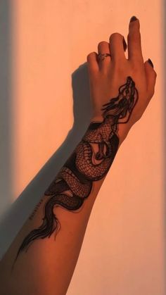 a woman's arm with a black dragon tattoo on it and a ring in the middle