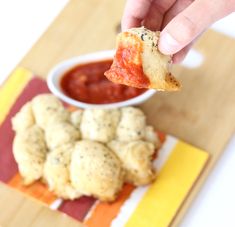 a person dipping sauce onto some food