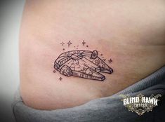 a woman's stomach with a small tattoo on it that has a spaceship flying through the sky