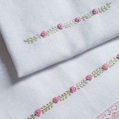 two white linens with pink roses on them