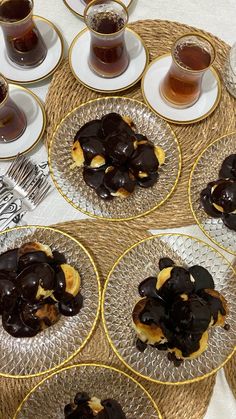 chocolate covered donuts on glass plates with saucers