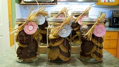 four jars filled with cookies sitting on top of a counter