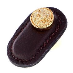 a gold ring sitting on top of a leather case