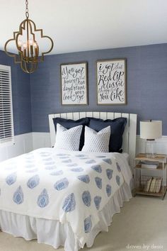 a bedroom with blue walls and white bedding