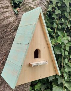 a bird house hanging on the side of a tree