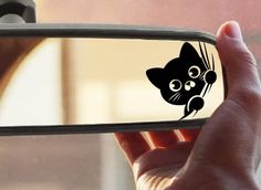 a person holding up a cell phone with a cat sticker on the side of it