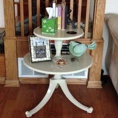 a white table with books and pictures on it in front of a wooden crib