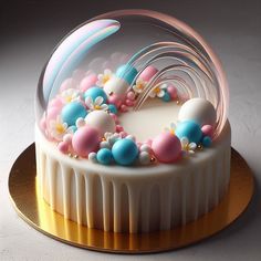 a white cake with pink, blue and yellow decorations on it's side sitting on a gold platter