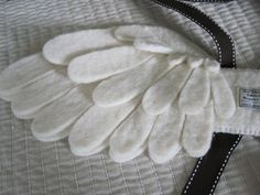 a close up of a white blanket with black trimmings on the edges and an angel wing design