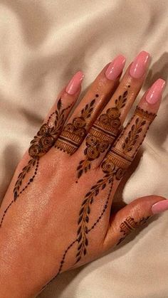 a woman's hand with henna tattoos on it