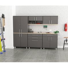 a kitchen with gray cabinets and white brick wall