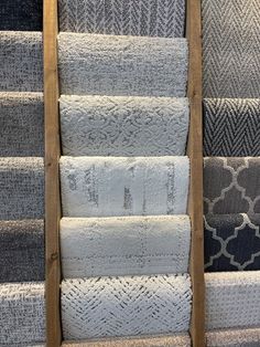 a ladder that is next to some rugs on the floor in a room with blue and gray carpet