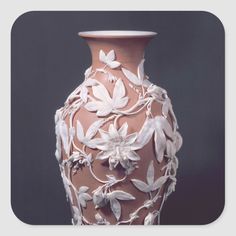 a vase with white flowers and vines on it's sides, against a black background