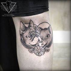 a black and white photo of two cats on the thigh with flowers around it's ankles