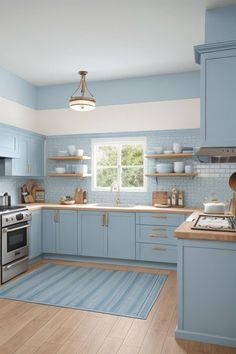 a kitchen with light blue cabinets and wooden floors is pictured in this image, there is a rug on the floor next to the stove