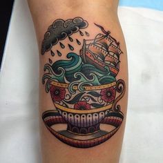 a tattoo on the leg of a person with a ship and clouds above it,