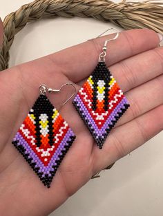 a pair of handmade beaded earrings on a person's palm