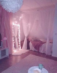 a bedroom with pink walls and lights on the ceiling is decorated in pastel colors